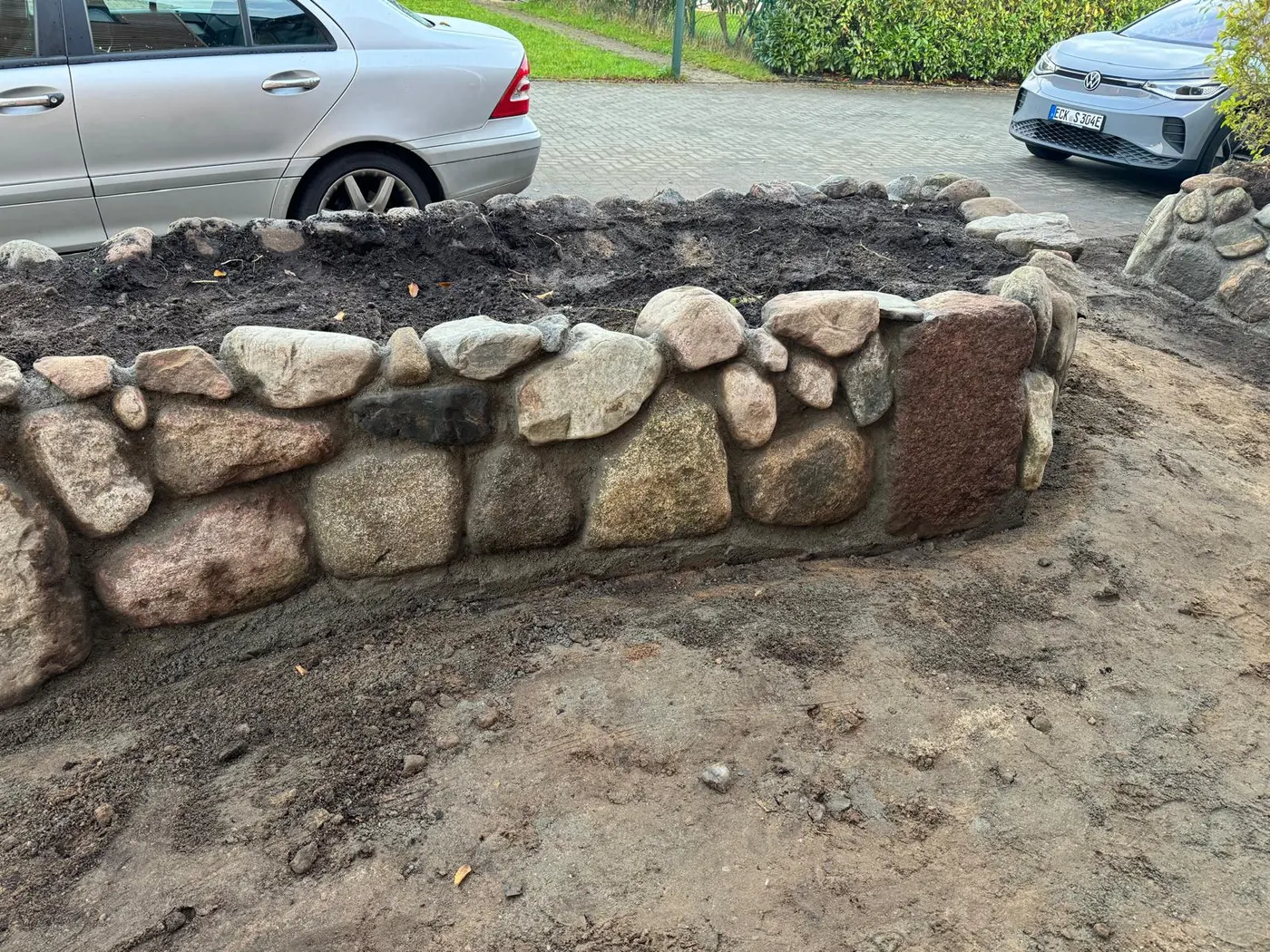 Natursteinmauer und eingefasster Pflanzbereich